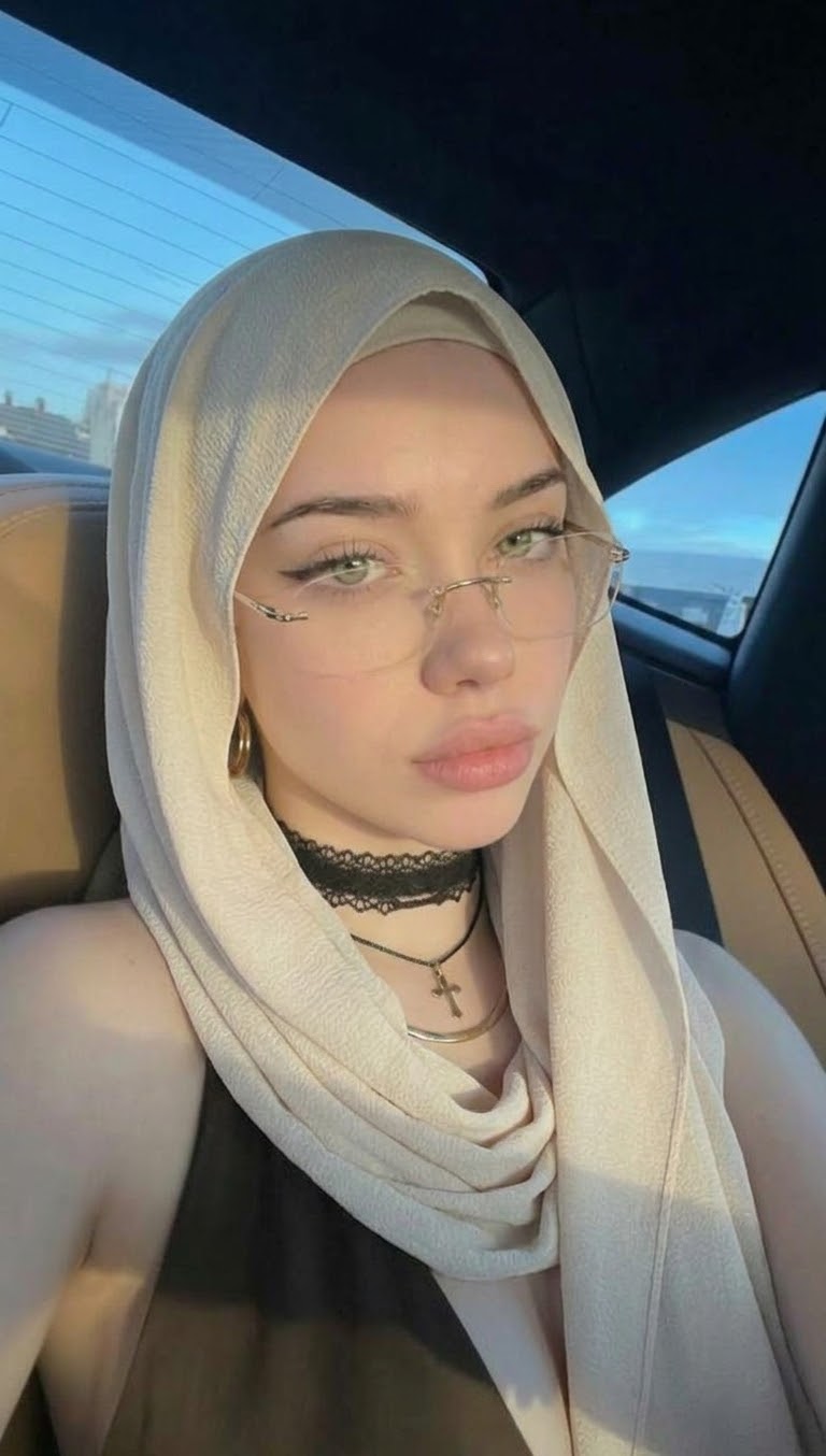 Portrait with a beige headscarf and glasses.