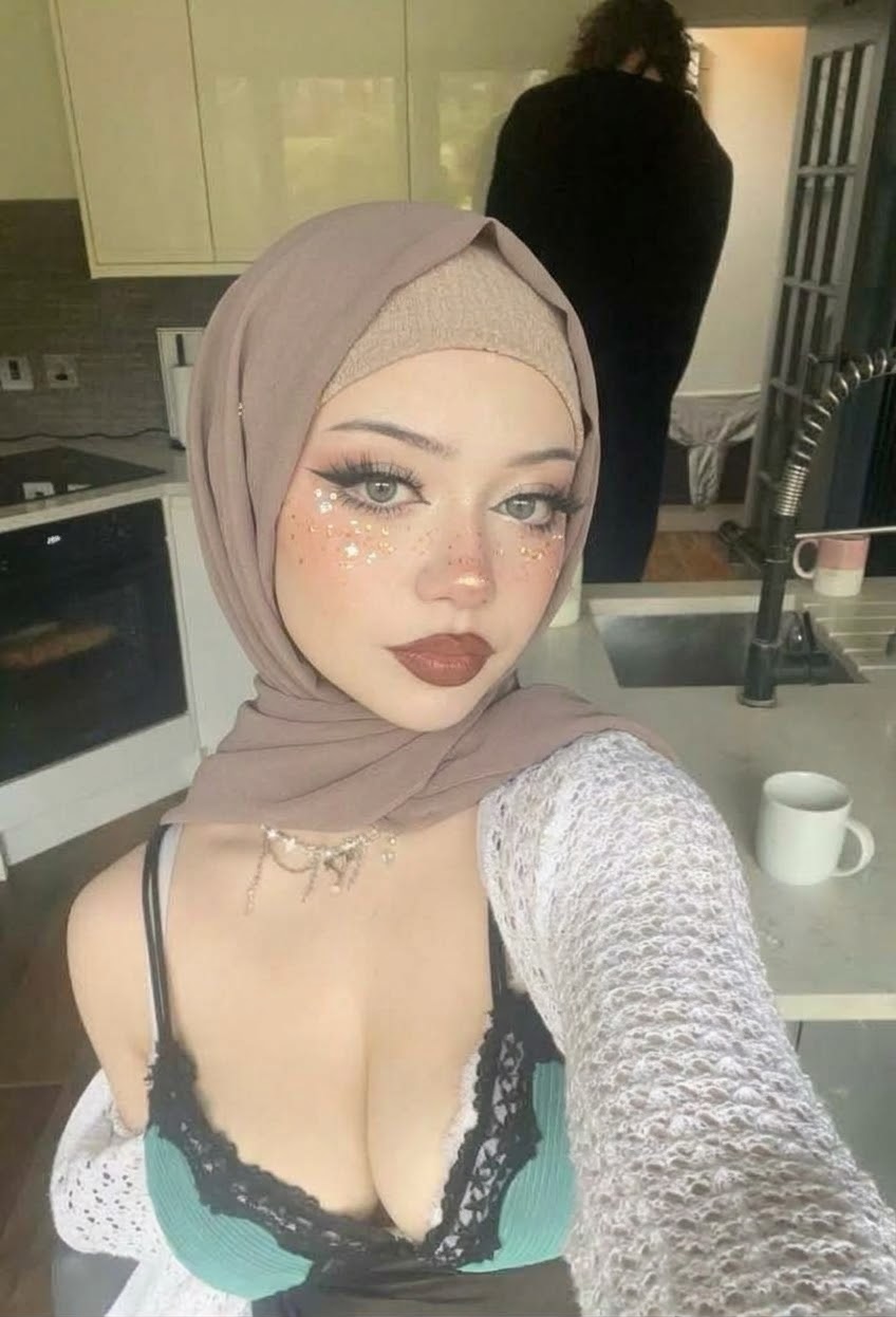 Portrait with a beige headscarf and white cardigan.