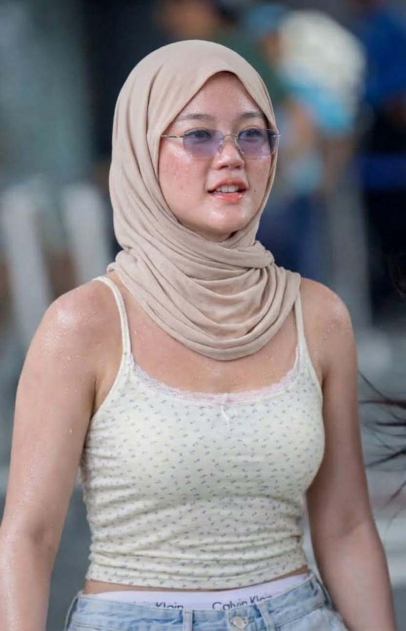 Portrait with a beige headscarf and glasses.