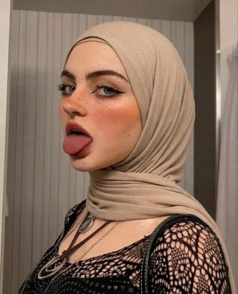 Portrait with a beige headscarf and black lace top.