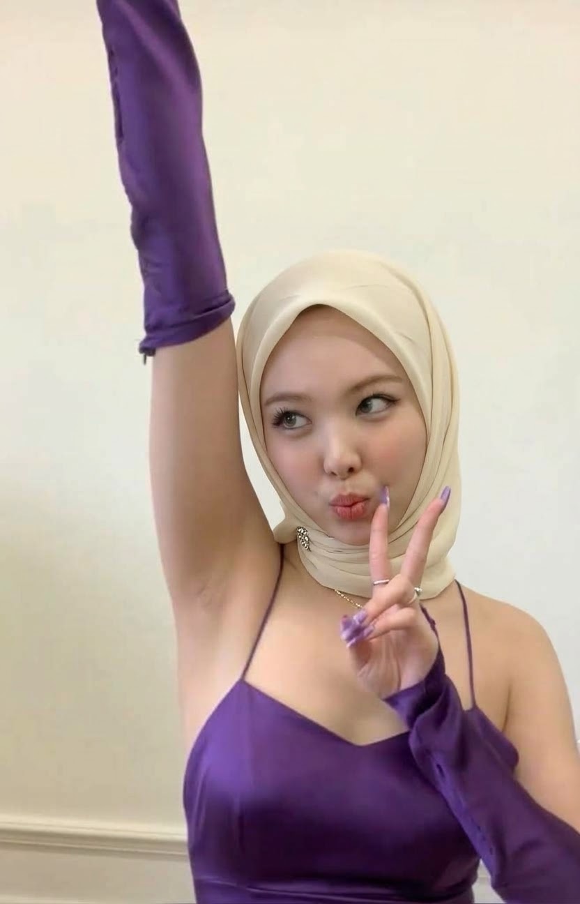 Portrait with a beige headscarf and purple outfit.
