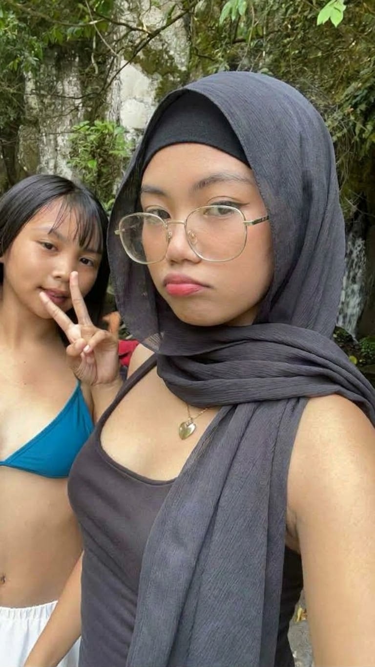 Portrait with a black headscarf and glasses.