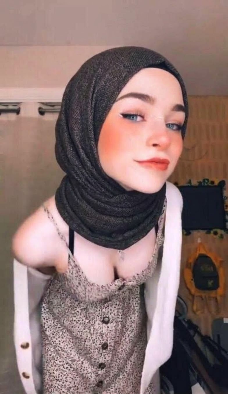 Textured black hijab and button-front lace top with a pale pink cardigan draped around the arms.