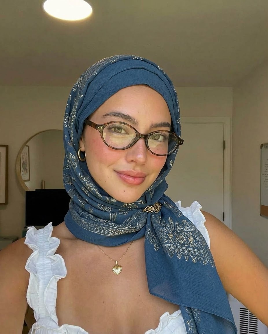 Portrait with a blue headscarf and glasses.