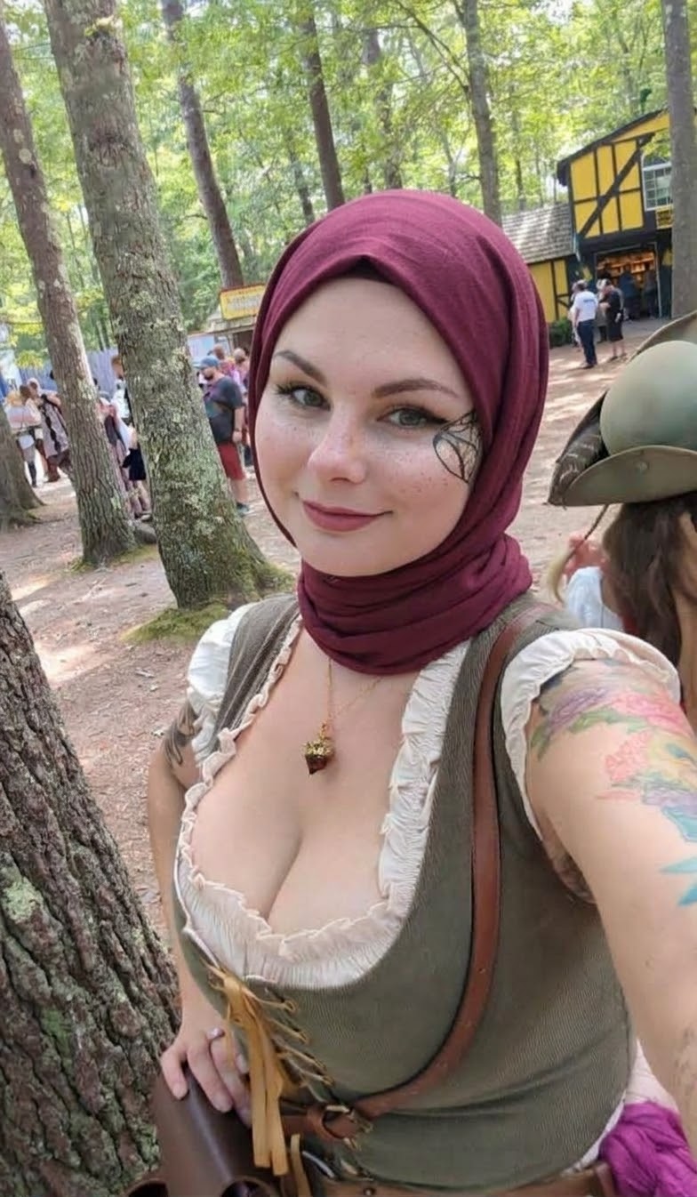 Portrait with a burgundy headscarf and green outfit.