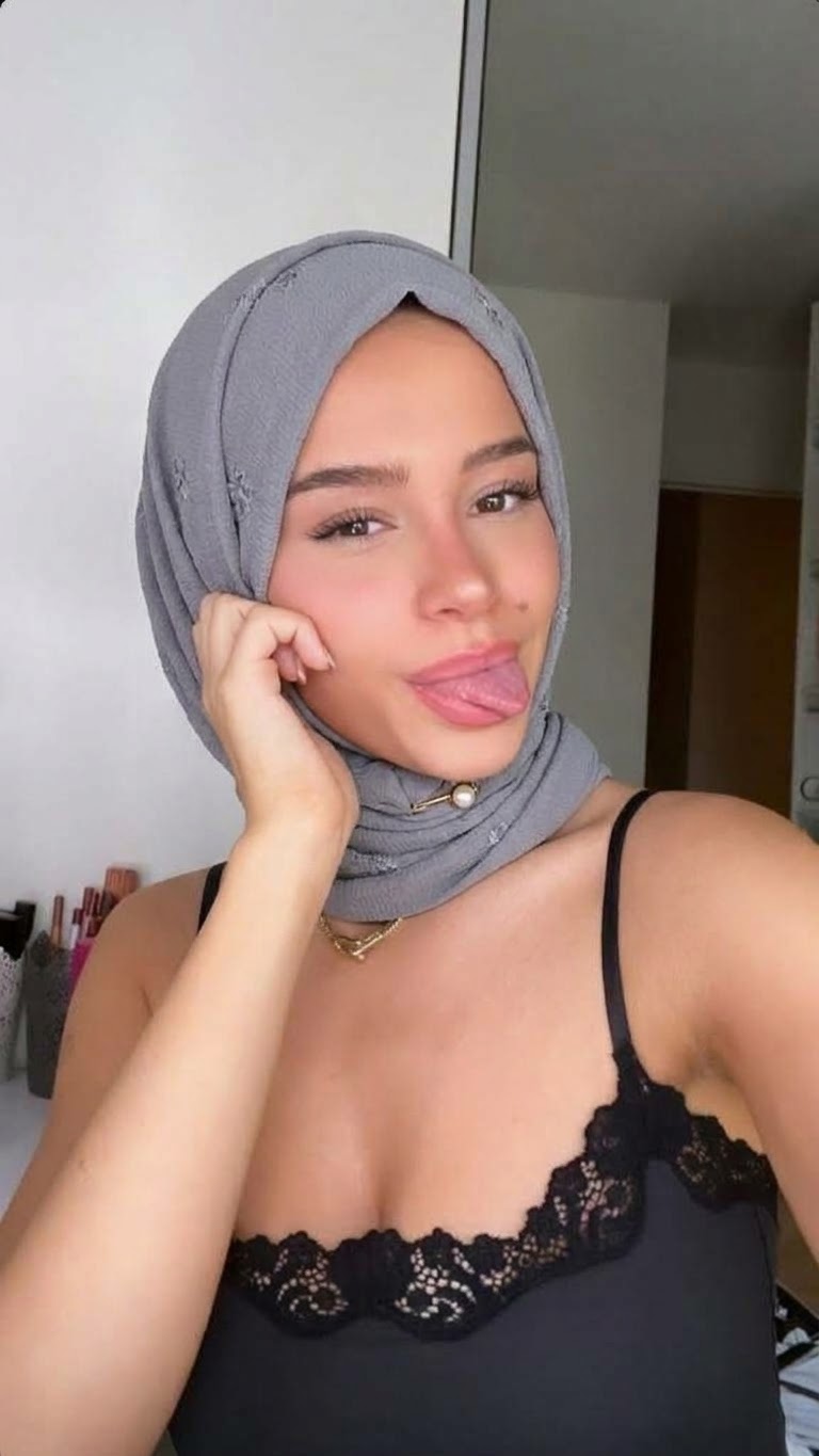 Portrait with a gray headscarf and black lace top.