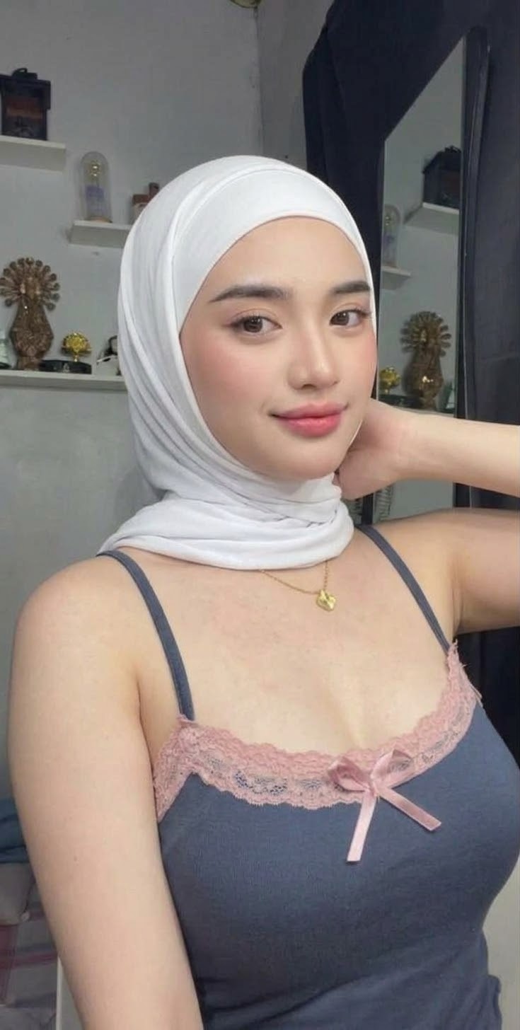Portrait with a white headscarf and dark top.