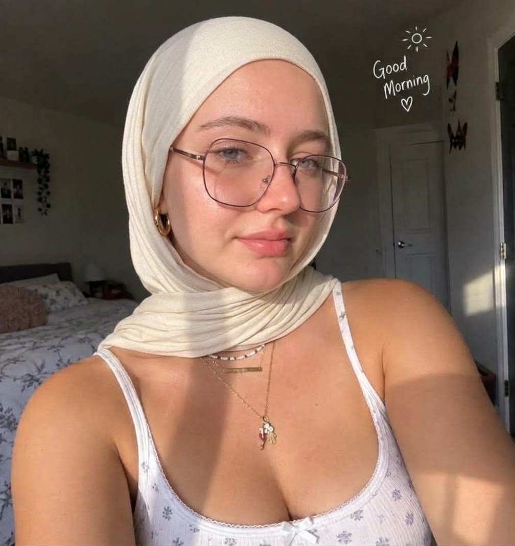 Portrait with a white headscarf and glasses.