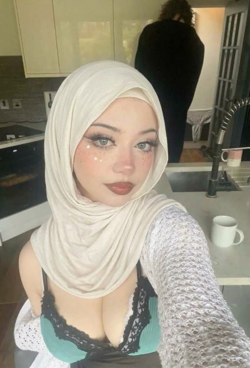 Portrait with a white headscarf and white cardigan.