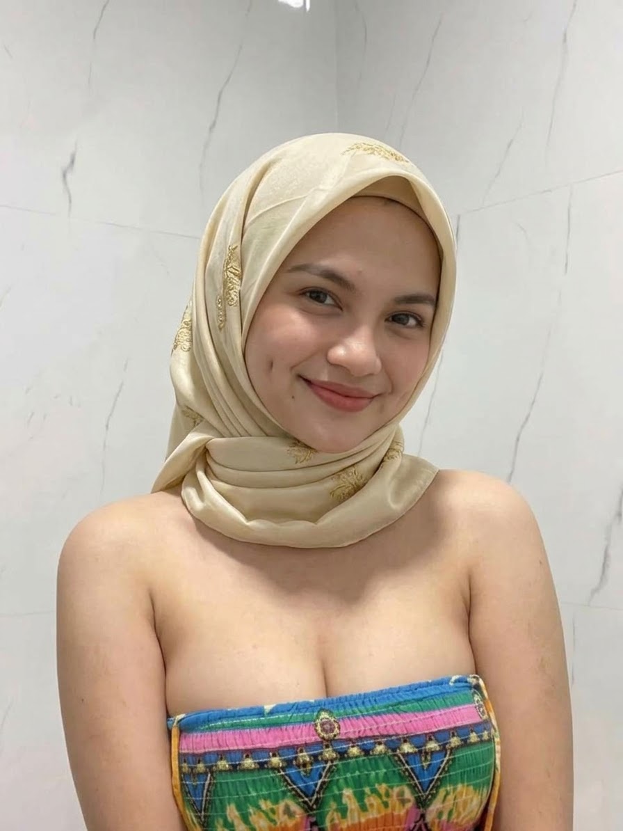 Portrait with a white headscarf and colorful top.